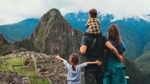 Família conhecendo vilarejo andino e interagindo com animais durante viagem ao Peru