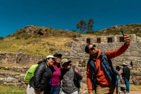 Guia explicando o trajeto e tirando dúvidas de família nas ruínas de Machu Picchu